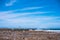 Minimal scenery of blue sky and rock beach with a tiny lady stan