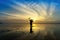 Minimal Silhouette of happy tourist with poles in hand above head on the beach.