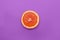 Minimal style, creative layout orange and grapefruit. Flat lay. Food concept. Half an orange on purple background.