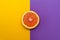 Minimal style, creative layout orange and grapefruit. Flat lay. Food concept. Half an orange on yellow purple background.