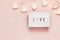 Minimal Valentine flat lay with word love on lightboard and garland. Love concept. Valentine`s day, copy space