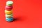 Minimalism. Bright red background for text with colorful macaroons on the edge of the photo