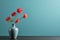 minimalism photo modern vase with orange flowers on a table with copy space on light blue background