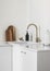 Minimalism simplicity kitchen interior - white ceramic sink with dispenser, dish brushes, electric kettle on a white table