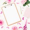 Minimalism workspace with clipboard, pink roses, petals and accessories on white background. Flat lay, top view. Blogger of freela