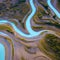 A minimalist aerial view of a winding river, with abstract patterns formed by the meandering flow of water5, Generative AI