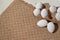 Minimalist aestethic Easter background with white eggs in eco package on a sand color jute rug, spring flat lay, copy space
