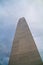 Minimalist Beige Tower Rising into Overcast Sky, Low Angle View