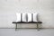 a minimalist black and white throw pillow on a concrete bench