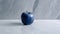 Minimalist Blue Apple On Polished Concrete: Functional Design With Tactile Surfaces