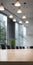 Minimalist business meeting room captured with selective focus on sleek conference table, with blurred participants in background