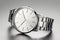 minimalist chic silver timepiece against gray background