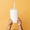 Minimalist Child Holding Cup Of Milk On Orange Background