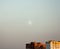 Minimalist cityscape with blue sky, white moon and urban dwelling houses skyscrapers. Landscape sunset