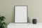 Minimalist and clean vertical black poster or photo frame mockup on the white table leaning against the room wall with vase and