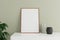 Minimalist and clean vertical wooden poster or photo frame mockup on the white table leaning against the room wall with vase and