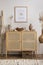 Minimalist composition of cozy and domestic space of living room with rattan commode, mock up poster frame, decoration, vase,