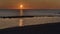Minimalist golden sunset at the beach with beautifull lights reflections on sea water between the cliffs untill the sky