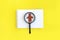 Minimalist job searching concept. Magnifier with abstract person, notepad on yellow background.