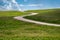 Minimalist landscape photo of prairie grassland in Custer State Park with blue sky clouds, as the road winds through