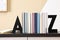 Minimalist letter bookends with books on table indoors