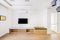 minimalist living room with a tv, a light wood sideboard with