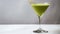Minimalist Matcha Martini. A pristine matcha martini cocktail graces a sleek martini glass, garnished with a crisp leaf