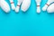 Minimalist photo of bowling pins over turquoise blue background