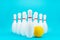 Minimalist photo of bowling pins over turquoise blue background