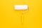 minimalist photo of clean paint roller with yellow handle on the yellow background