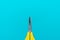 Minimalist photo of yellow children`s scissors on the turquoise blue background