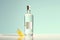 minimalist presentation of a clear spirit bottle with a lemon wedge on a pastel background