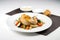 minimalist presentation of roasted chicken and vegetables on white plate