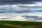 Minimalist of rolling agriculture field under cloudy skies