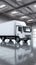 Minimalist scene white delivery truck contrasts against gray industrial flooring