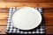 Minimalist setting White plate tray on wooden tablecloth, top view