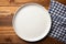 Minimalist setting White plate tray on wooden tablecloth, top view