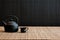 a minimalist shot of a cast iron japanese teapot on a bamboo mat