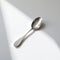 Minimalist Spoon On Sunlit White Surface