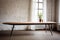 a minimalist wooden table with metal legs in a loft space