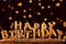 Minimalistic background with golden candles without fire letters in cake close up. Garland of yellow bokeh circles at