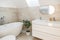 A minimalistic bathroom with standalone bathtub, long sink and ficus plant