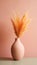 A minimalistic composition featuring a pink vase with delicate fluffy peach fuzz color pampas grass on a pastel background