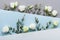 Minimalistic concept of paper card decorated beautiful white flowers and eucalyptus leaves on pastel background top view. Flat lay