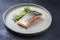 Minimalistic design salmon fish filet glazed with avocado and wasabi creme in a sliced cucumber  on a modern design plate