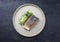 Minimalistic design salmon fish filet glazed with avocado and wasabi creme in a sliced cucumber on a modern design plate