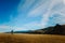 Minimalistic landscape of a person walking in the field on a bright sunny day