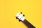 Minimalistic layout photo with a cute small white ukulele fretboard with nylon strings on a colorful yellow background with a copy