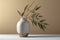 Minimalistic modern vase in neutral color with a branch of green leaves. Contemporary composition on beige background. Created