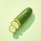 Minimalistic presentation of a cucumber against serene pastel background